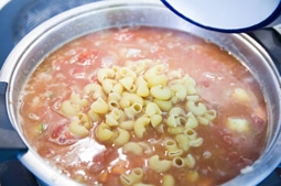 Añadiendo la pasta a la sopa minestrone
