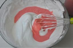 Mezclando puré de fresas con el merengue