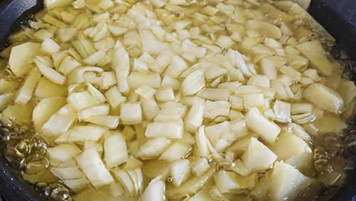 echando cebolla para la tortilla de patatas